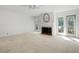 Bright, open living area features a fireplace, neutral carpet, and access to outdoor spaces at 9 Pelican Pl, Belleair, FL 33756