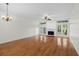 Large living room with hardwood floors, ceiling fan, and fireplace with access to the patio at 9 Pelican Pl, Belleair, FL 33756