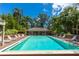 Relaxing community pool area with plenty of seating and lush tropical landscaping at 9 Pelican Pl, Belleair, FL 33756