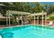 Community pool area with a pergola, lounge chairs, and outdoor seating, perfect for recreation and relaxation at 9 Pelican Pl, Belleair, FL 33756