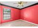 Bedroom with red and black walls, ceiling fan and wood-look flooring at 16201 Country Crossing Dr, Tampa, FL 33624