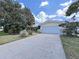 Ranch-style home with a large driveway and well-maintained lawn at 1385 Embassy Dr, Clearwater, FL 33764