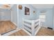 Light-filled hallway with hardwood floors and a stained glass window at 6619 Livingston N Ave, St Petersburg, FL 33702