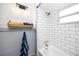 Clean bathroom featuring white subway tile, a bathtub, and a wooden shelf at 6619 Livingston N Ave, St Petersburg, FL 33702