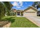 Tan one-story house with blue door and nicely landscaped yard at 1905 Masters Way, Plant City, FL 33566