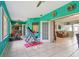 Sunroom with teal walls and home exercise equipment at 1905 Masters Way, Plant City, FL 33566