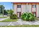 Front view of two-story townhome with orange trim and lush landscaping at 1655 58Th S Ter # 1, St Petersburg, FL 33712