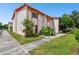 Side view of a two-story townhome with orange trim and lush landscaping at 1655 58Th S Ter # 1, St Petersburg, FL 33712