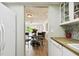 Kitchen with a view into the dining area, butcher block countertops, and white cabinets at 1655 58Th S Ter # 1, St Petersburg, FL 33712