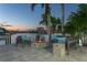 Evening view of a waterfront patio with fire pit and seating area at 2829 Skimmer Point S Dr, Gulfport, FL 33707