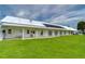 White community building with covered patio and lawn at 3843 Damian Dr, Zephyrhills, FL 33541