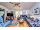 Living room with two sofas, wood floors, and a large TV at 3843 Damian Dr, Zephyrhills, FL 33541