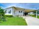 White single-wide manufactured home with carport and well-maintained landscaping at 3843 Damian Dr, Zephyrhills, FL 33541