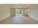 Bright living room featuring wood-look floors and sliding glass doors leading to backyard at 7110 Moss Ledge Run, Land O Lakes, FL 34637