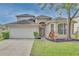Two-story house with a two-car garage and landscaped yard at 7110 Moss Ledge Run, Land O Lakes, FL 34637