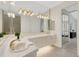 Bright bathroom features tile floors, white cabinetry, gold fixtures and mirrors with access to the main bedroom at 4251 Preserve Pl, Palm Harbor, FL 34685