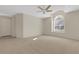Spacious bedroom with neutral carpet, ceiling fan, and a large window providing ample natural light at 4251 Preserve Pl, Palm Harbor, FL 34685