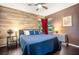 Spacious bedroom with wood-look walls, large bed, and ceiling fan at 4940 Willow Ridge Ter, Valrico, FL 33596