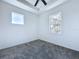 Bright bedroom with neutral carpet, a ceiling fan, and natural light streaming through two windows at 2404 1/2 E Chelsea, Tampa, FL 33610