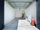 An empty garage with a high ceiling with paint cans and an orange cone in the corner at 2404 1/2 E Chelsea, Tampa, FL 33610