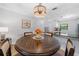 Cozy dining area featuring wood table, modern chandelier, and view into the kitchen at 2700 Nebraska Ave # 4-103, Palm Harbor, FL 34684