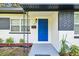 Updated front entrance with a bright blue door and landscaping at 815 St Francis St, Brooksville, FL 34601
