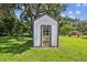 Wooden shed with a glass paneled door in a grassy yard at 815 St Francis St, Brooksville, FL 34601