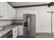 Updated kitchen with stainless steel refrigerator and white shaker cabinets at 815 St Francis St, Brooksville, FL 34601