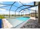 Relaxing screened-in pool and spa with patio furniture at 8861 Forge Breeze Loop, Wesley Chapel, FL 33545