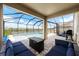 Screened-in pool and spa with patio furniture and fire pit at 8861 Forge Breeze Loop, Wesley Chapel, FL 33545