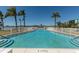 Inviting community pool with palm trees and water views at 1893 Shore S Dr # 215, South Pasadena, FL 33707