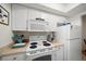 Well-equipped kitchen with white cabinets and stainless steel appliances at 2704 2Nd St # 7, Indian Rocks Beach, FL 33785