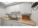 Modern kitchen with white cabinets and a stainless steel sink at 2704 2Nd St # 7, Indian Rocks Beach, FL 33785