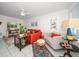Cozy living area with an orange sectional sofa and a large TV at 2704 2Nd St # 7, Indian Rocks Beach, FL 33785