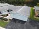 Aerial view of a light blue house with a garage and lush landscaping at 12026 Boynton Ln # Gb32, New Port Richey, FL 34654