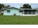 Rear view of house showing teal exterior and Florida room at 12026 Boynton Ln # Gb32, New Port Richey, FL 34654