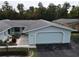 Front view of a light blue house with a gray roof and a two-car garage at 12026 Boynton Ln # Gb32, New Port Richey, FL 34654