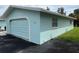 Attached garage with arched door and light blue exterior at 12026 Boynton Ln # Gb32, New Port Richey, FL 34654