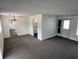 Spacious living room with gray carpet, a chandelier, and views into the kitchen at 12026 Boynton Ln # Gb32, New Port Richey, FL 34654