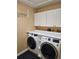 Bright laundry room with white cabinets, washer, and dryer at 3582 Fairway Forest Dr, Palm Harbor, FL 34685