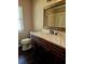 Bathroom with dark wood vanity, marble countertop, and large mirror at 3582 Fairway Forest Dr, Palm Harbor, FL 34685