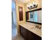 Bathroom with dark brown vanity, quartz countertop, and large mirror at 3582 Fairway Forest Dr, Palm Harbor, FL 34685
