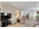 Living room with a large TV, recliner, and view into the dining area at 1400 Tarpon Woods Blvd # B5, Palm Harbor, FL 34685