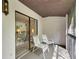Screened balcony with sliding door access and two chairs at 1400 Tarpon Woods Blvd # B5, Palm Harbor, FL 34685