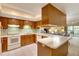 Bright kitchen features wood cabinets, white appliances, and a pass-through to the dining area at 1400 Tarpon Woods Blvd # B5, Palm Harbor, FL 34685