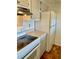 Kitchen with white appliances, wood cabinets, and tiled floor at 2525 W Bay Dr # B32, Largo, FL 33770