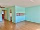 Open living room with wood look flooring and pass-through window to the kitchen at 2525 W Bay Dr # B32, Largo, FL 33770