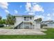 Two-story building with gray siding, a staircase, and a paved area at 402 E Emma St, Tampa, FL 33603