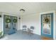 Quaint front porch with teal doors and two folding chairs at 402 E Emma St, Tampa, FL 33603