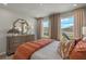 Main bedroom with large windows and orange bedding at 31564 Woodland Race Loop, Wesley Chapel, FL 33545